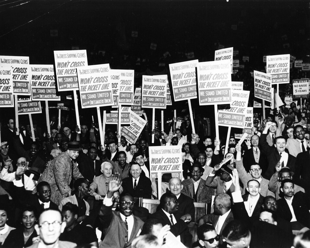 "White and African American males hold signs that read: 'The Dress Shipping Clerks' Won't Cross the Picket Line. We Stand United with the Dressmakers Union!' 1958." by Kheel Center, Cornell University Library is licensed under CC BY 2.0